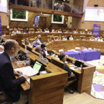 Vue de l'assemblée et de M. Vienne en premier plan parlant au micro.