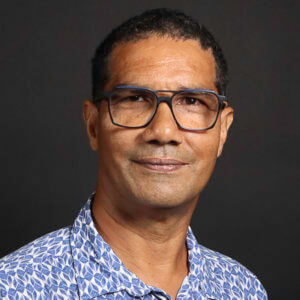 Portrait d'homme brun à lunettes, chemise à motifs bleus clairs