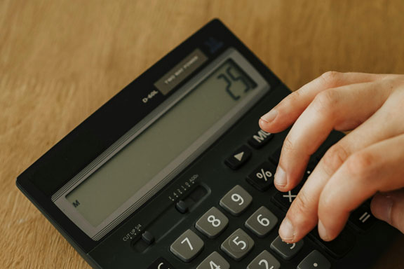 Photographie d'une main tape sur une calculatrice